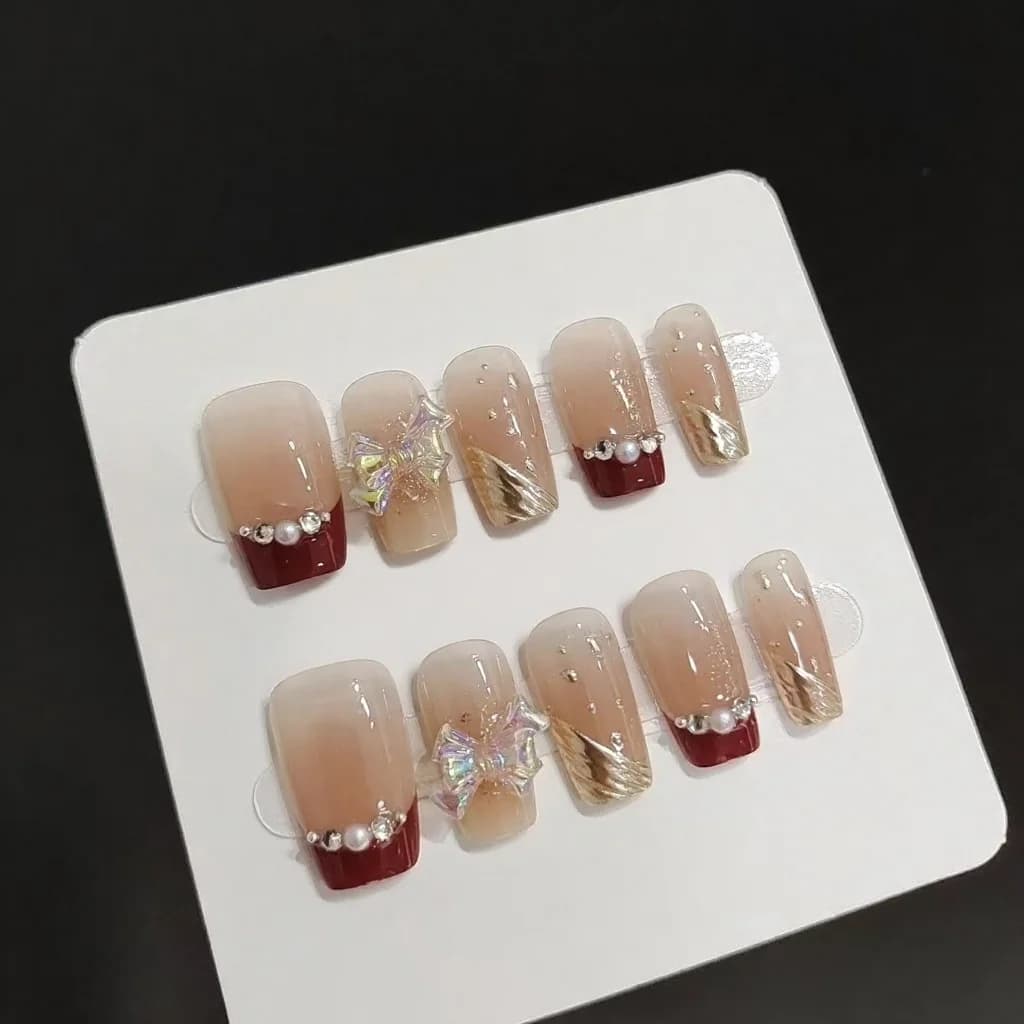 Korte French Tip Kunstnagels met Gouden Glitter en Strikdesign