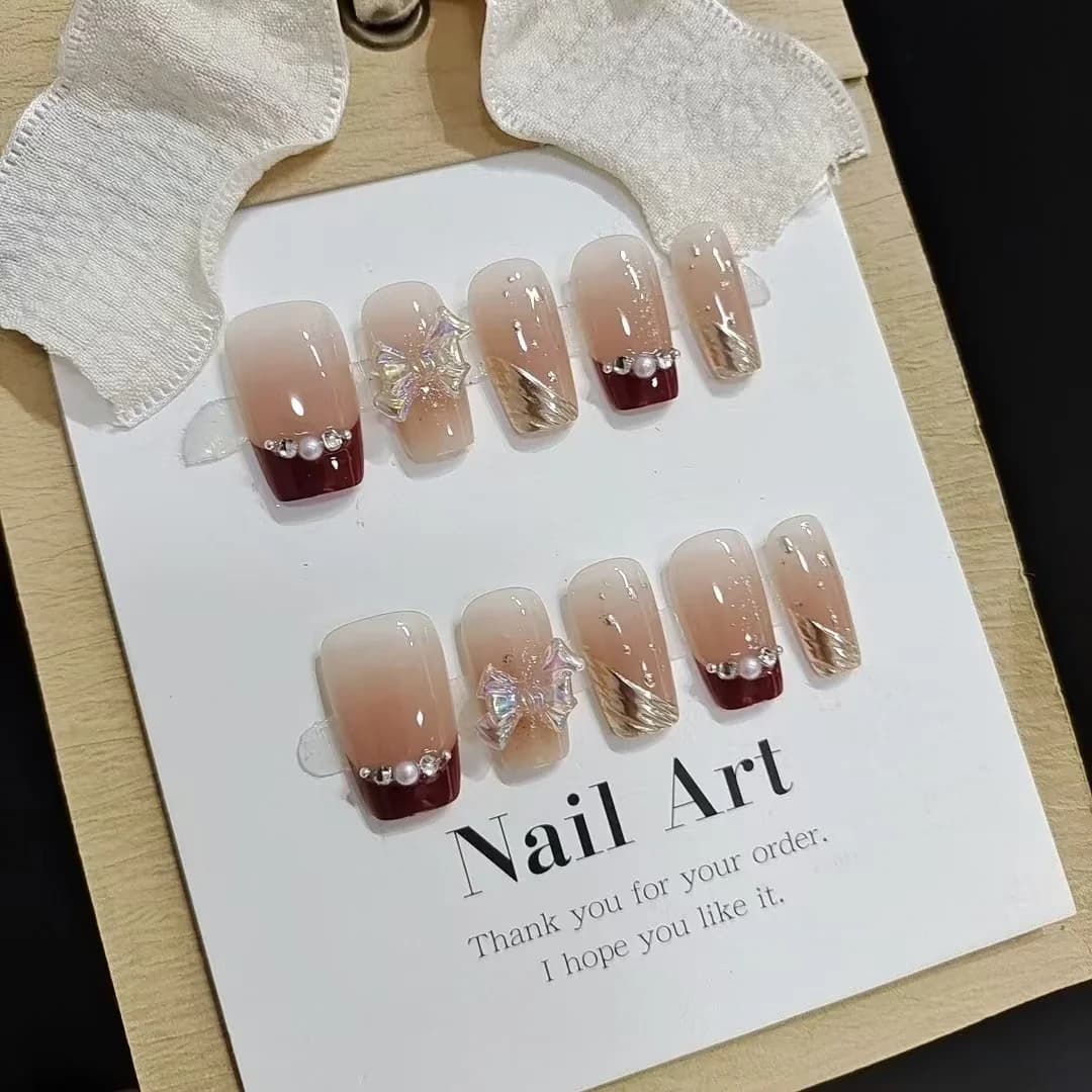 Korte Franse Tip Press-On Nails met Goudglitter en Strikdesign